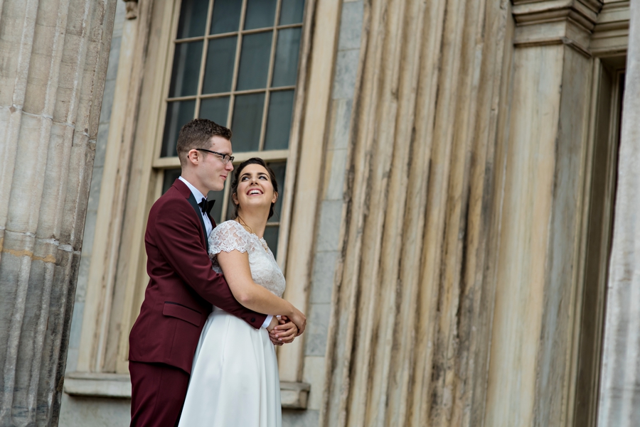 A groom holds his bride and laughs.